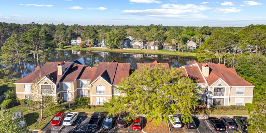 Spacious apartment complex near Tampa with pond and lush greenery, ideal for residential living.