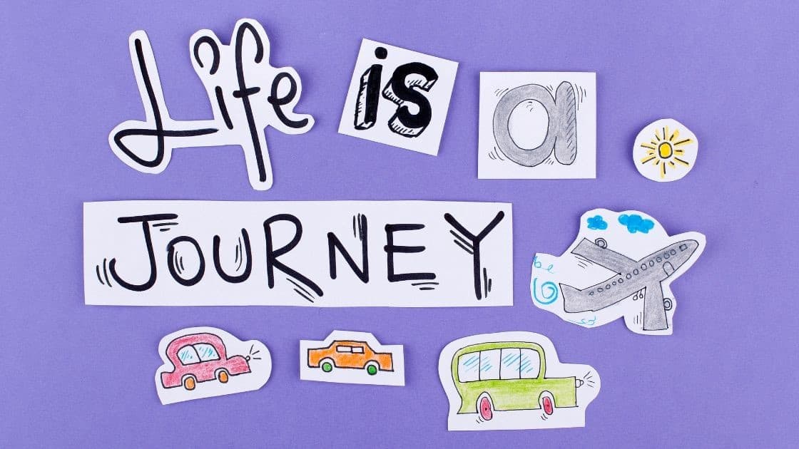 Travel-themed paper cutouts and drawings with the words "Life is a journey" on a purple background.