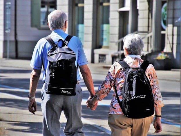 Older couple walking with backpacks in downtown Tampa, Florida.