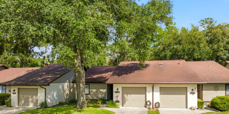 Bright Tampa suburban homes with manicured lawns, lush trees, and residential driveways, showcasing appealing house exteriors.