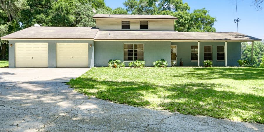 Modern suburban house with a spacious front yard and two-car garage.