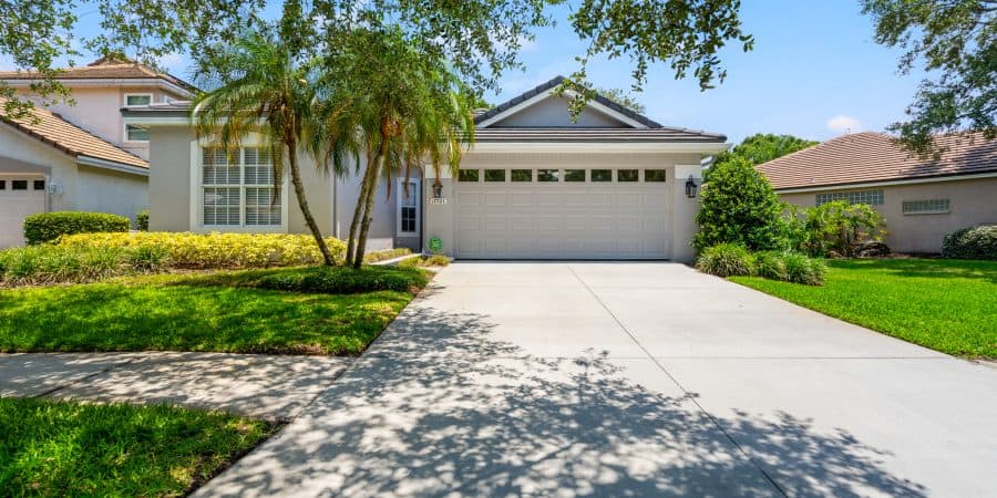 Lush front yard with well-maintained landscaping and a bright, clean driveway in Tampa.