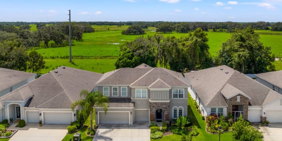 Spacious modern house with landscaped yard in a suburban neighborhood near green fields.