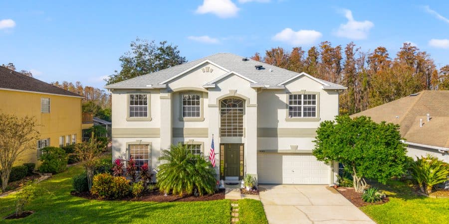 Bright white luxury home for sale in Tampa with landscaped yard and modern design.