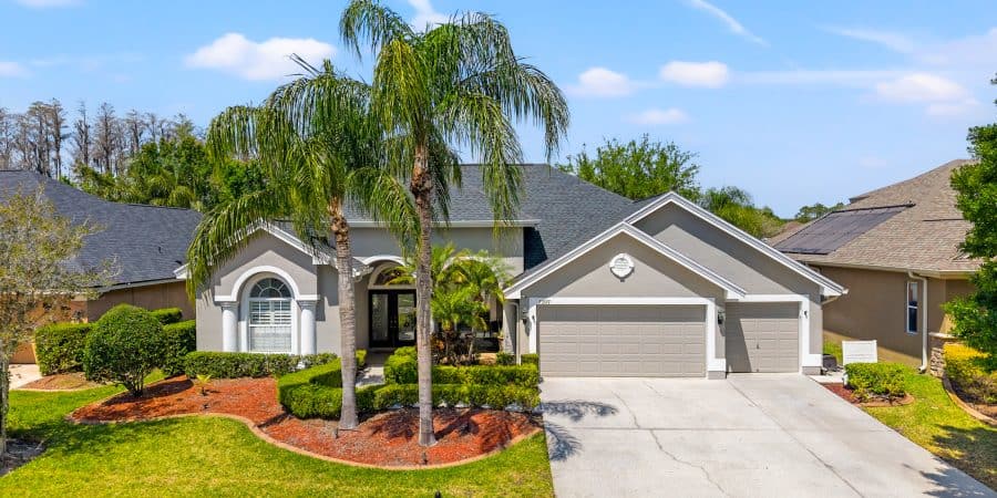 Modern suburban house with lush landscaping and palm trees in Tampa, Florida.