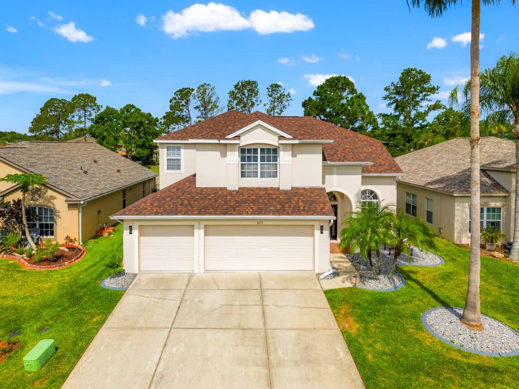 Spacious modern house with a well-manicured lawn and tropical landscaping in Tampa, Florida.