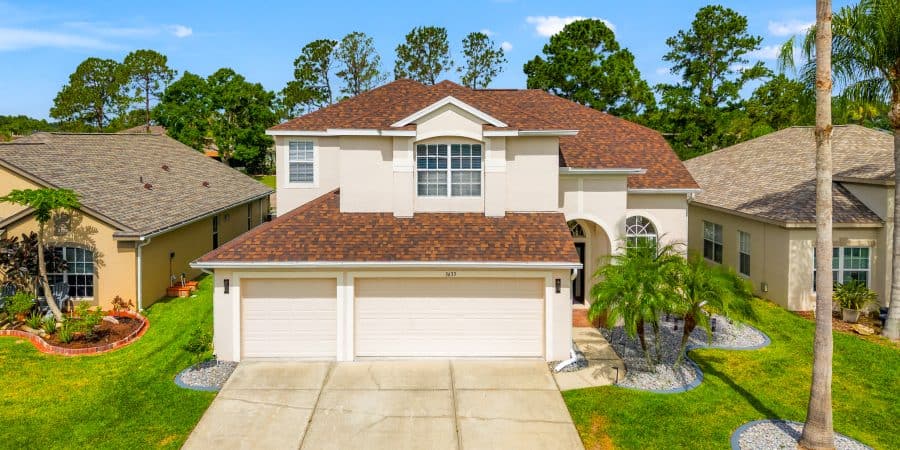 Spacious modern house with a well-manicured lawn and tropical landscaping in Tampa, Florida.